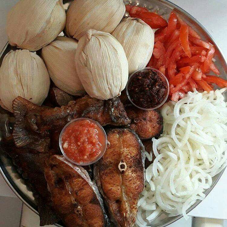 Plat de dokounou présenté avec du poisson, des légumes et du piment noir
