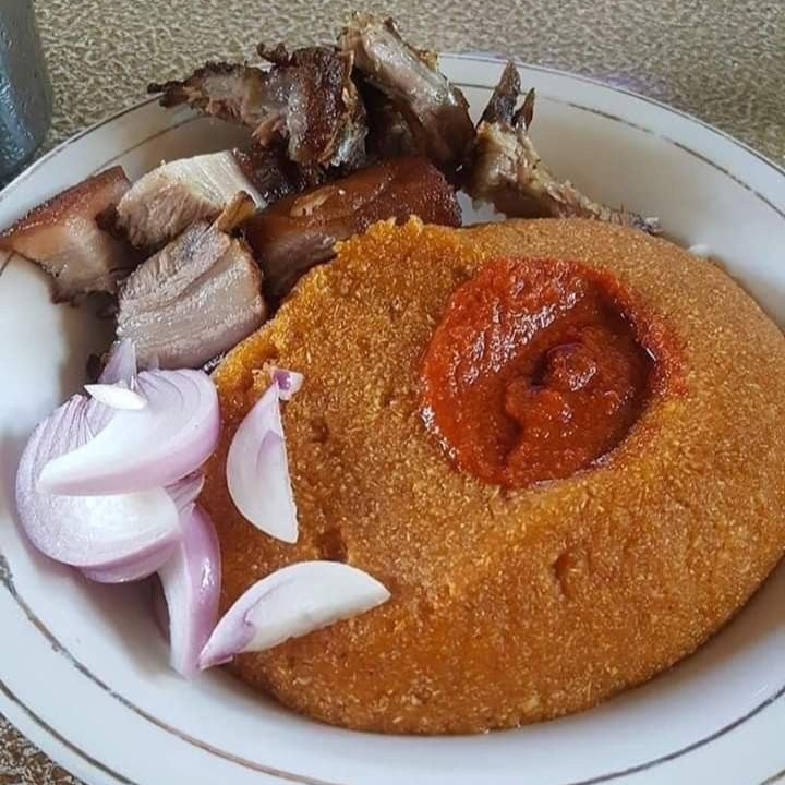 eba de gari présenté avec de la viande et du piment rouge écrasé